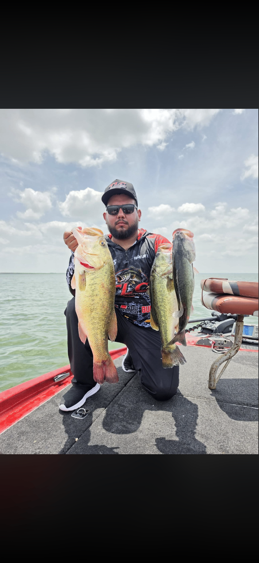 Luis holding two giant largemouth bass on the boat